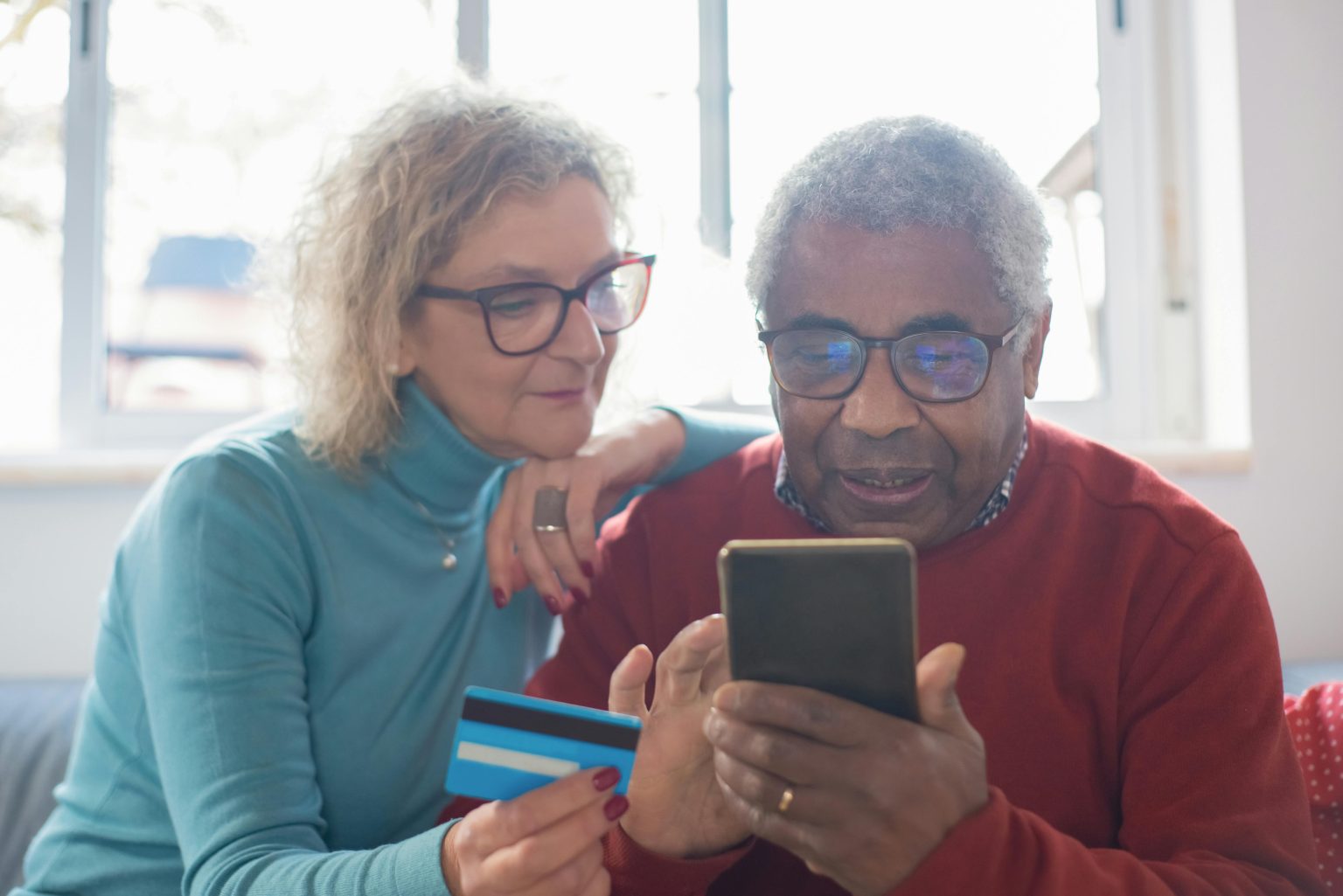 A couple in their seventies at home, looking over paperwork together